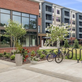Exterior view of building with bike rack & dog park at Eclipse